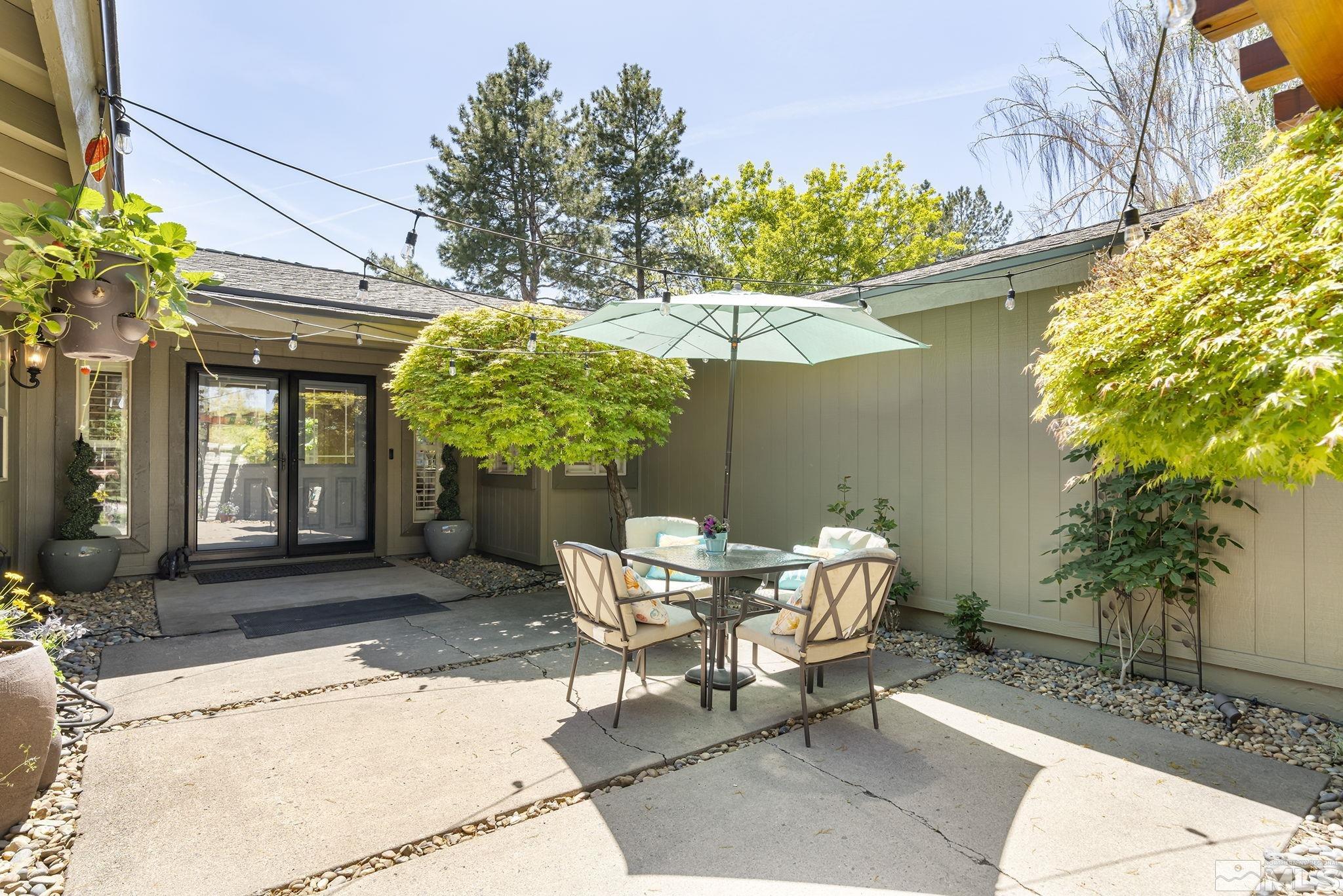 1490 Shewmaker Court Reno, NV 89509 - Photo 6 of 40 a patio with a table and chairs and potted plants
