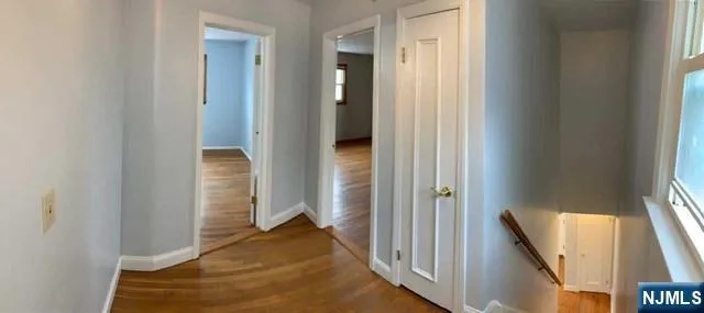 a view of a hallway with wooden floor and stairs