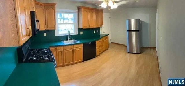 a kitchen with stainless steel appliances granite countertop a refrigerator a stove and a sink