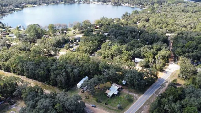 an aerial view of a house with a yard and lake view