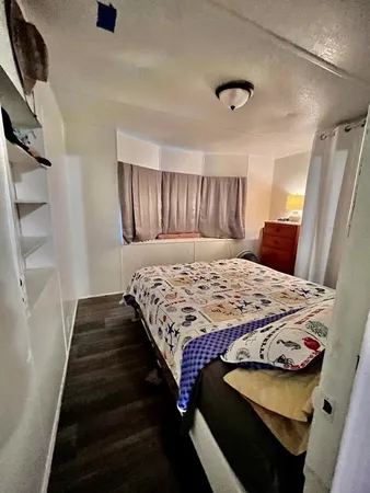a bedroom with a bed and wooden floor