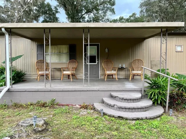 a view of a chair and table in back yard of the house