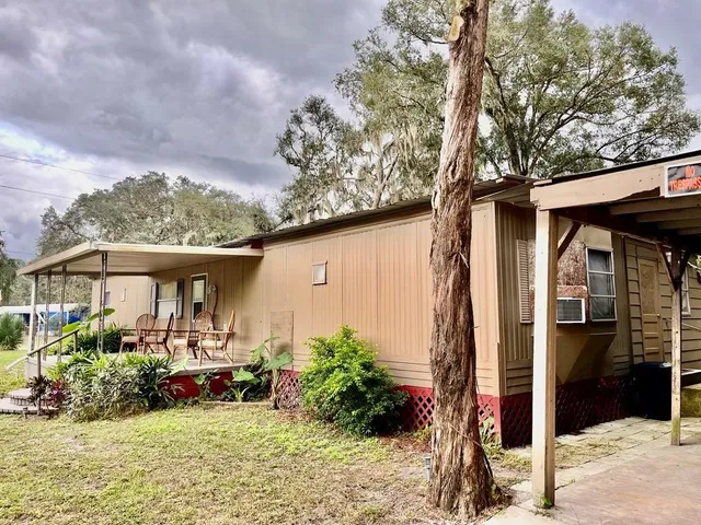 a view of a house with backyard sitting area and garden