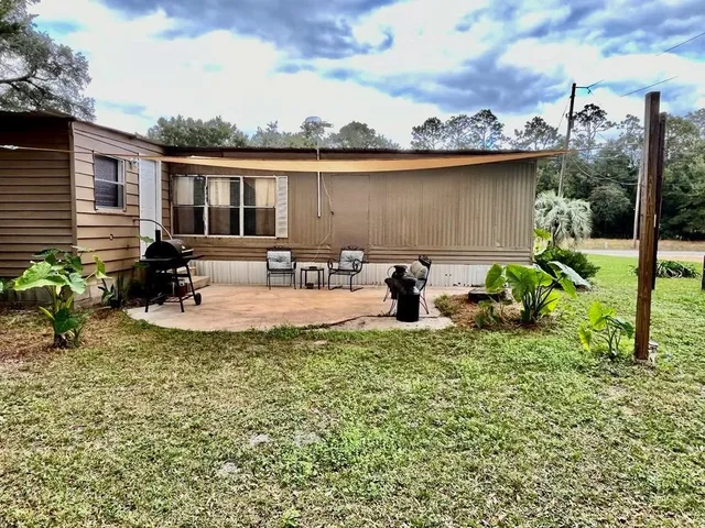 a backyard of a house with table and chairs