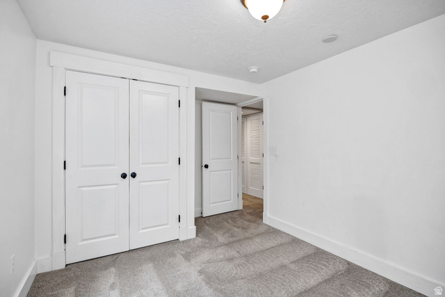 2912 South 1080th Street West Logan, UT 84321 - Photo 22 of 43 Light gray carpeted flooring, white walls, white trim, and white bi-fold closet doors with black hardware