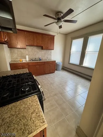 a kitchen with granite countertop a stove a sink and a refrigerator