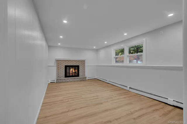 an empty room with wooden floor and fireplace
