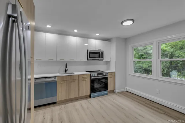 a kitchen with stainless steel appliances granite countertop a stove a sink and a refrigerator