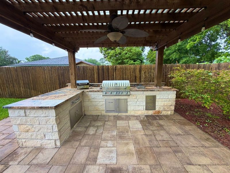913 Cannan Drive Angleton, TX 77515 - Photo 37 of 39 a view of a patio with table and chairs with wooden fence and plants