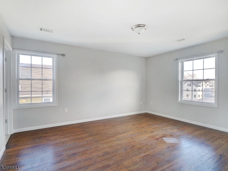 521 Walnut Street, Unit 2 Elizabeth, NJ 07201 - Photo 12 of 13 an empty room with wooden floor and windows