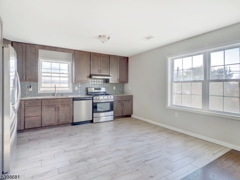 521 Walnut Street, Unit 2 Elizabeth, NJ 07201 - Photo 4 of 13 a kitchen with stainless steel appliances cabinets a sink and a large window