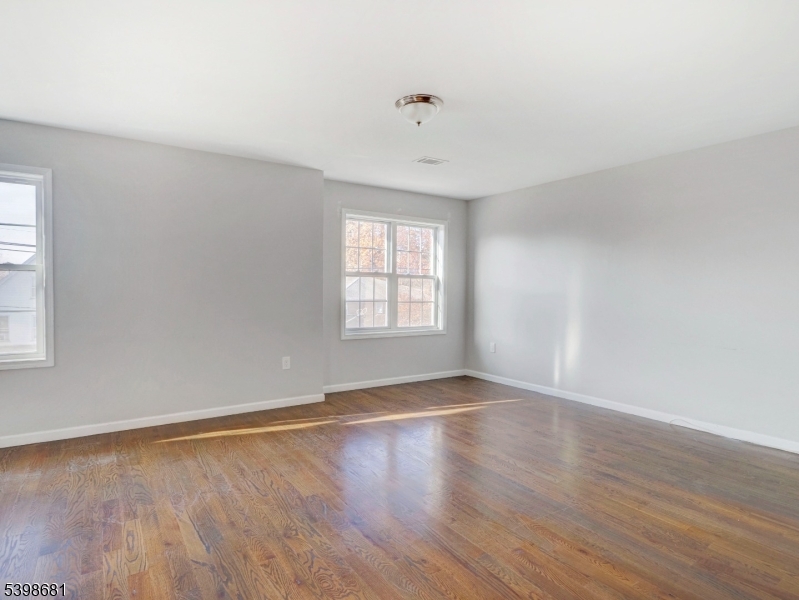 521 Walnut Street, Unit 2 Elizabeth, NJ 07201 - Photo 5 of 13 an empty room with wooden floor and windows