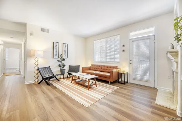 a living room with furniture and a wooden floor