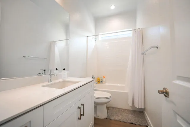 a bathroom with a sink a toilet and shower