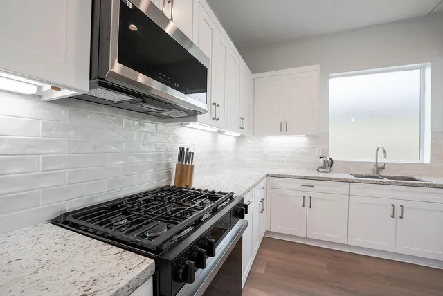 a kitchen with stainless steel appliances a stove a sink and a microwave