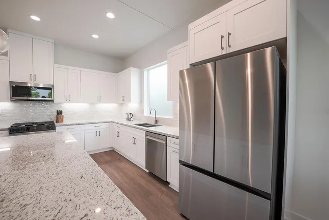 a kitchen with stainless steel appliances a refrigerator sink and cabinets