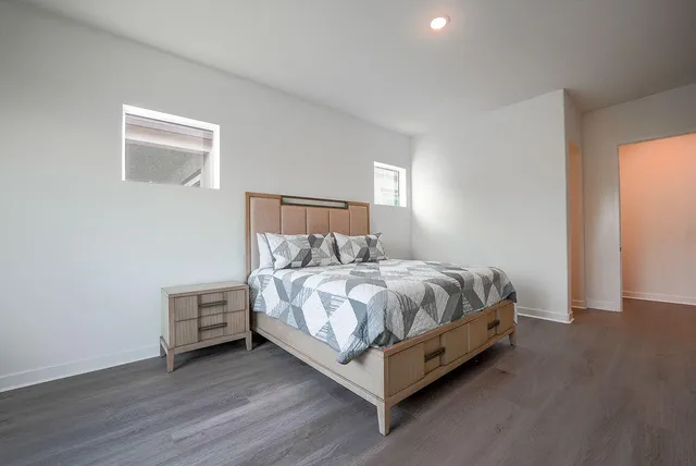 a bed sitting in a spacious bedroom next to a window