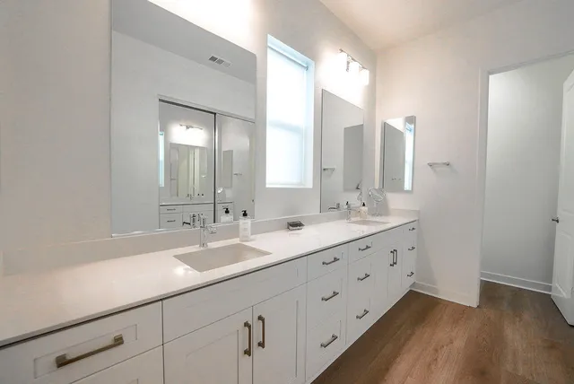 a bathroom with double sink and a mirror