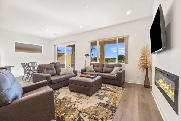 a living room with patio furniture and a floor to ceiling window