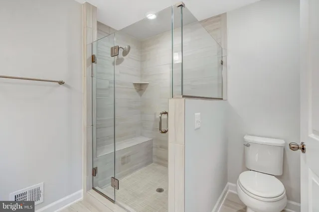 a bathroom with a shower a toilet and a sink