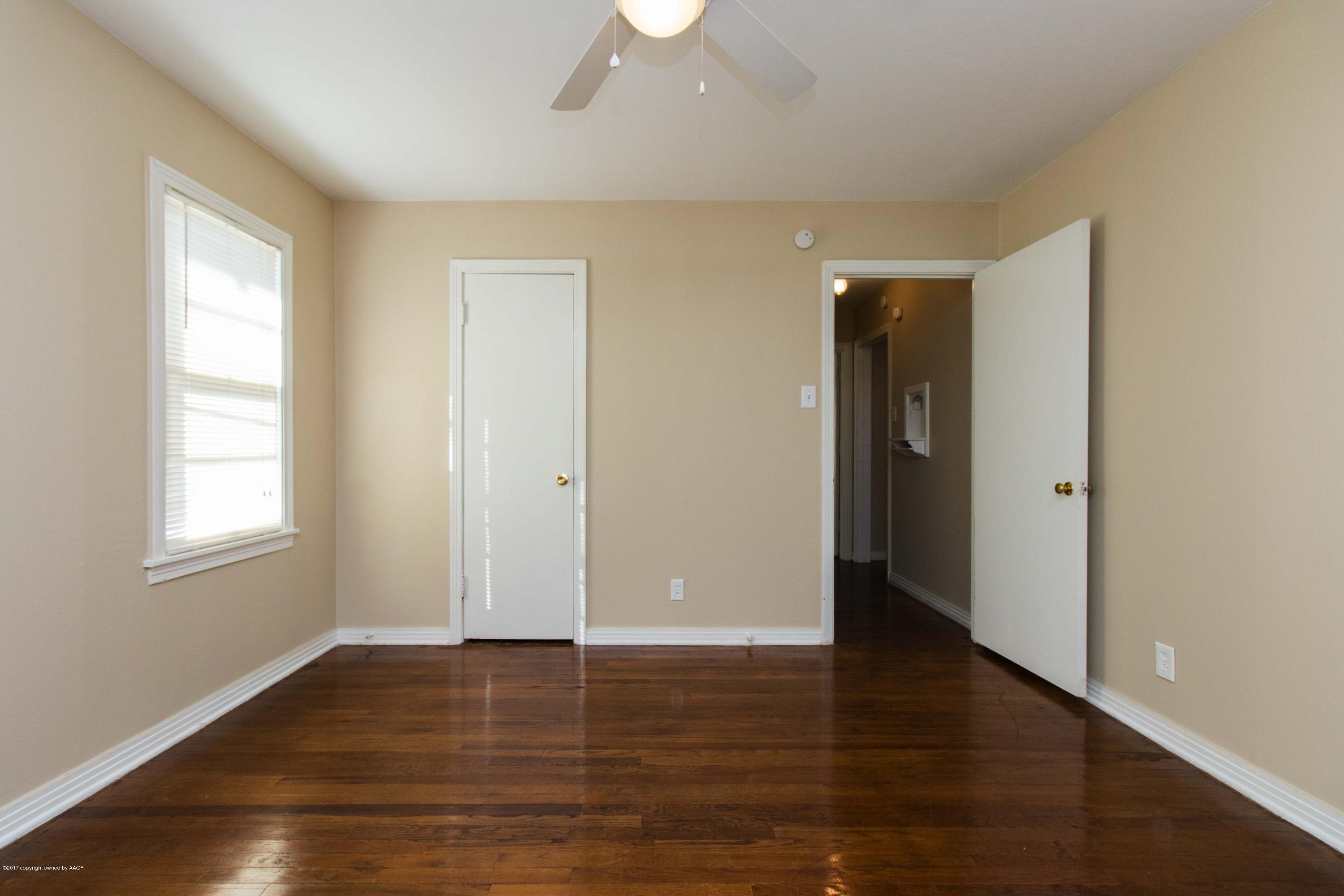 4314 Parker Street Amarillo, TX 79110 - Photo 11 of 20 an empty room with wooden floor and windows