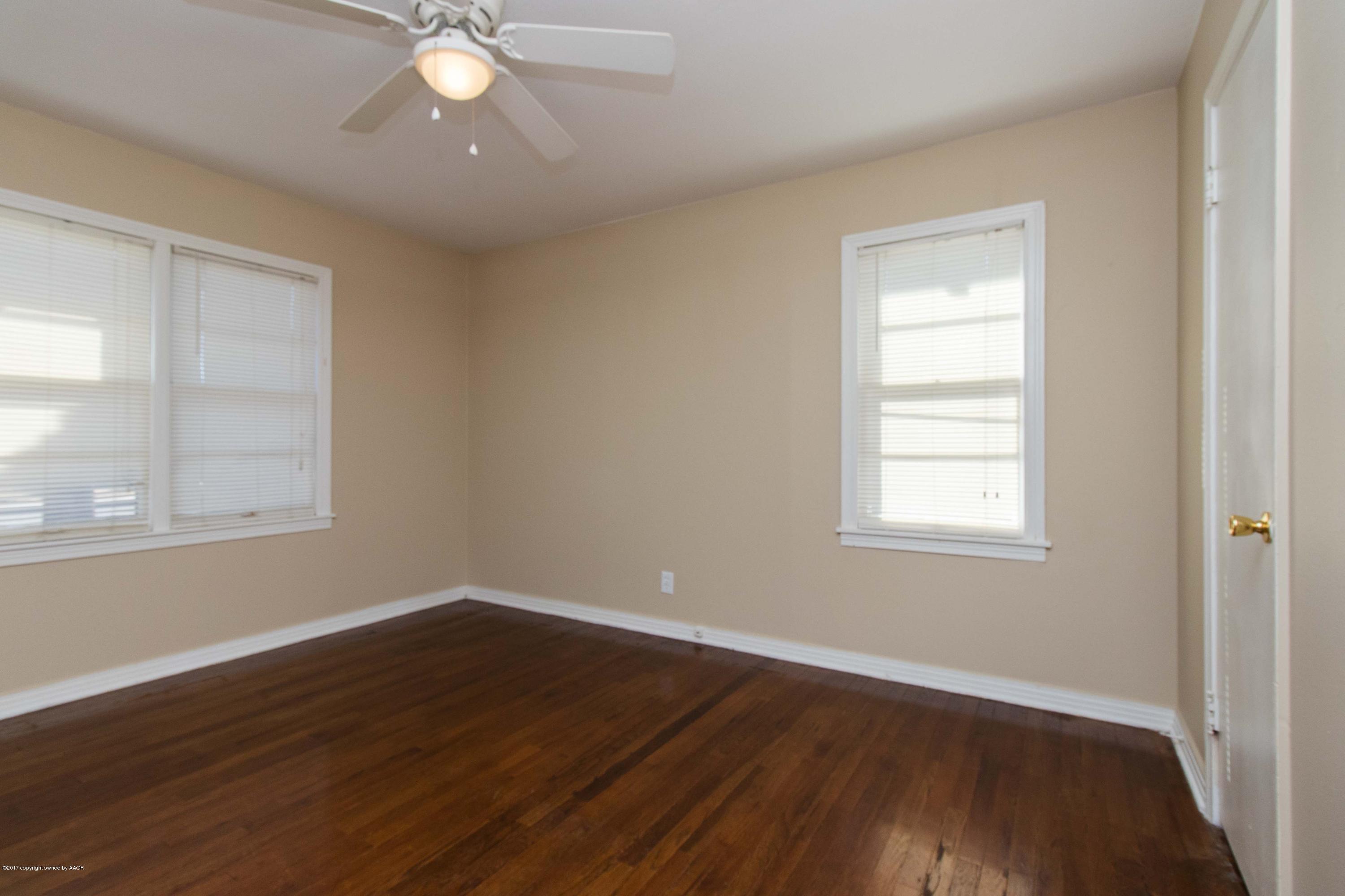 4314 Parker Street Amarillo, TX 79110 - Photo 13 of 20 an empty room with wooden floor and windows