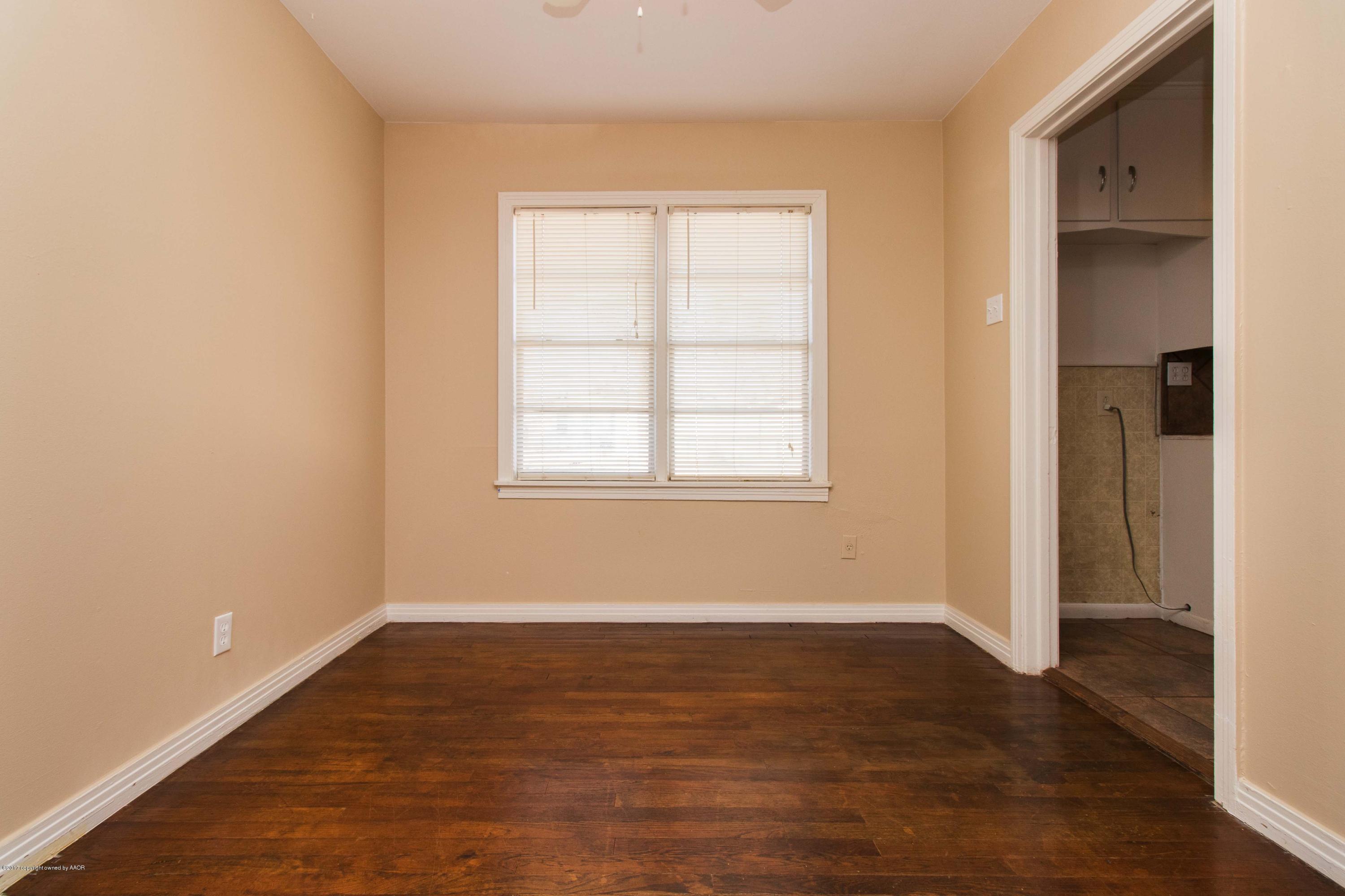 4314 Parker Street Amarillo, TX 79110 - Photo 6 of 20 an empty room with wooden floor and windows