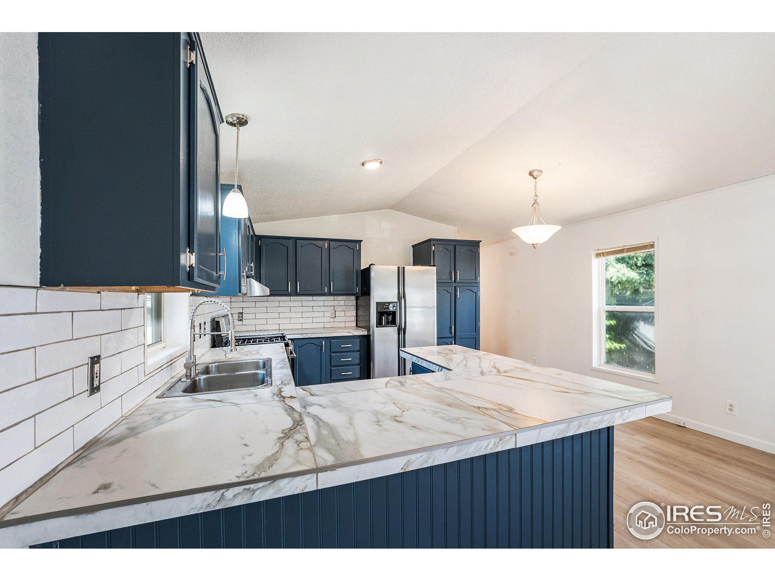 230 North 2nd Street, Unit 26 Berthoud, CO 80513 - Photo 7 of 21 a kitchen with stainless steel appliances kitchen island granite countertop a sink refrigerator and cabinets