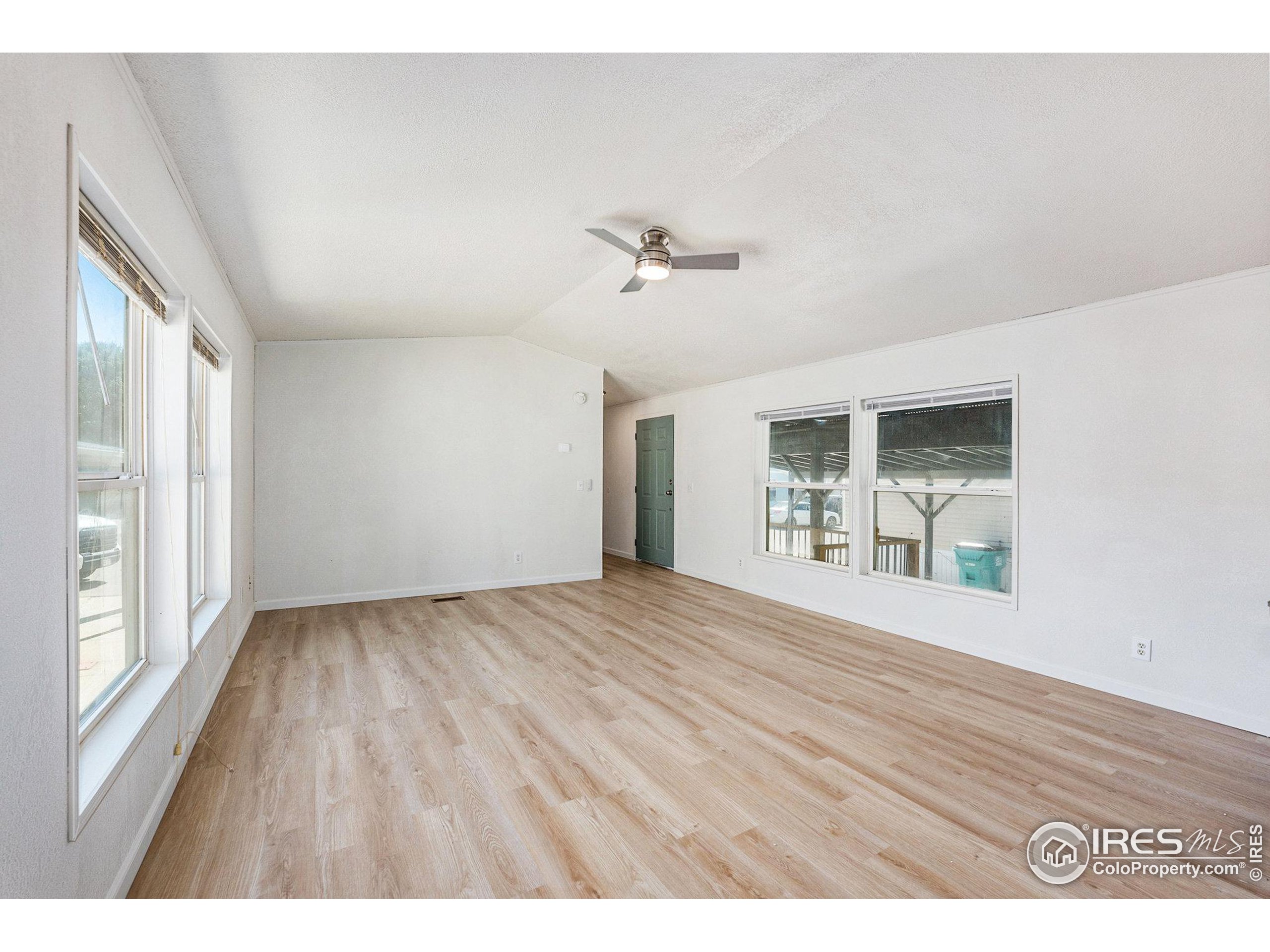 230 North 2nd Street, Unit 26 Berthoud, CO 80513 - Photo 10 of 21 a view of an empty room with a window and wooden floor