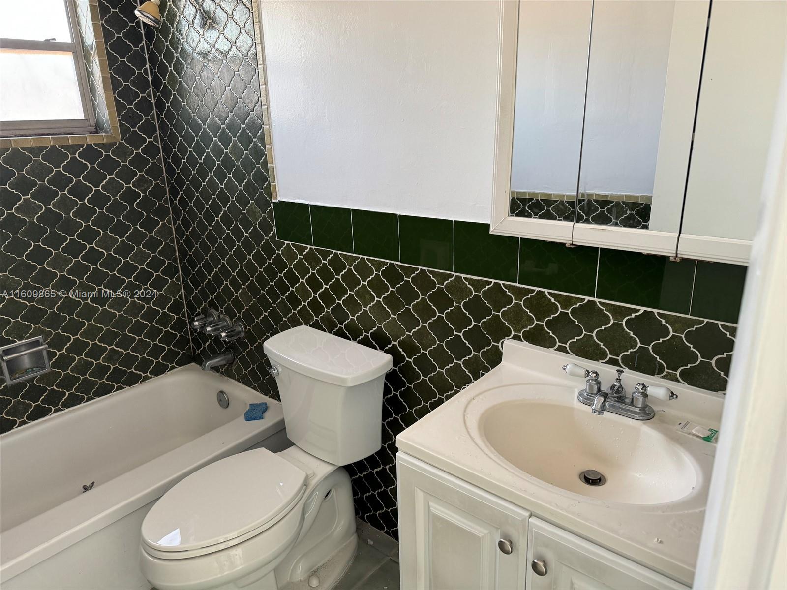 2008 Pierce Street, Unit 3 Hollywood, FL 33020 - Photo 5 of 9 a bathroom with a sink a toilet and a mirror