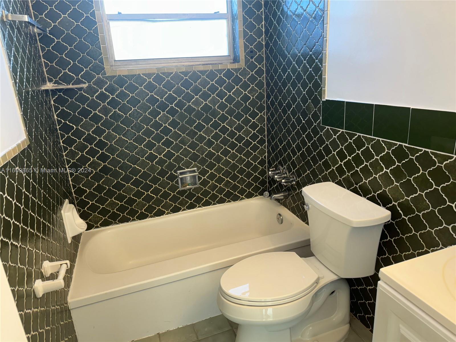 2008 Pierce Street, Unit 3 Hollywood, FL 33020 - Photo 9 of 9 a white toilet sitting next to a white wall