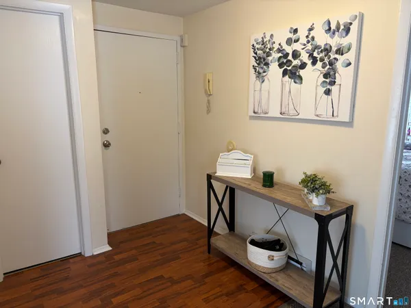 a view of a hallway with wooden floor and a workspace