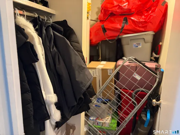 a view of walk in closet with clothes and shoes