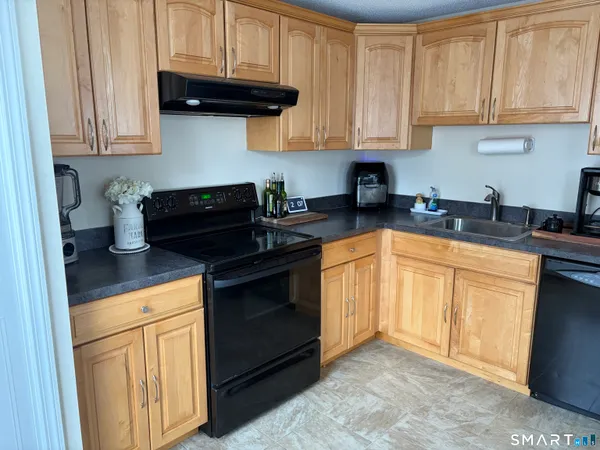 a kitchen with granite countertop a stove sink and cabinets