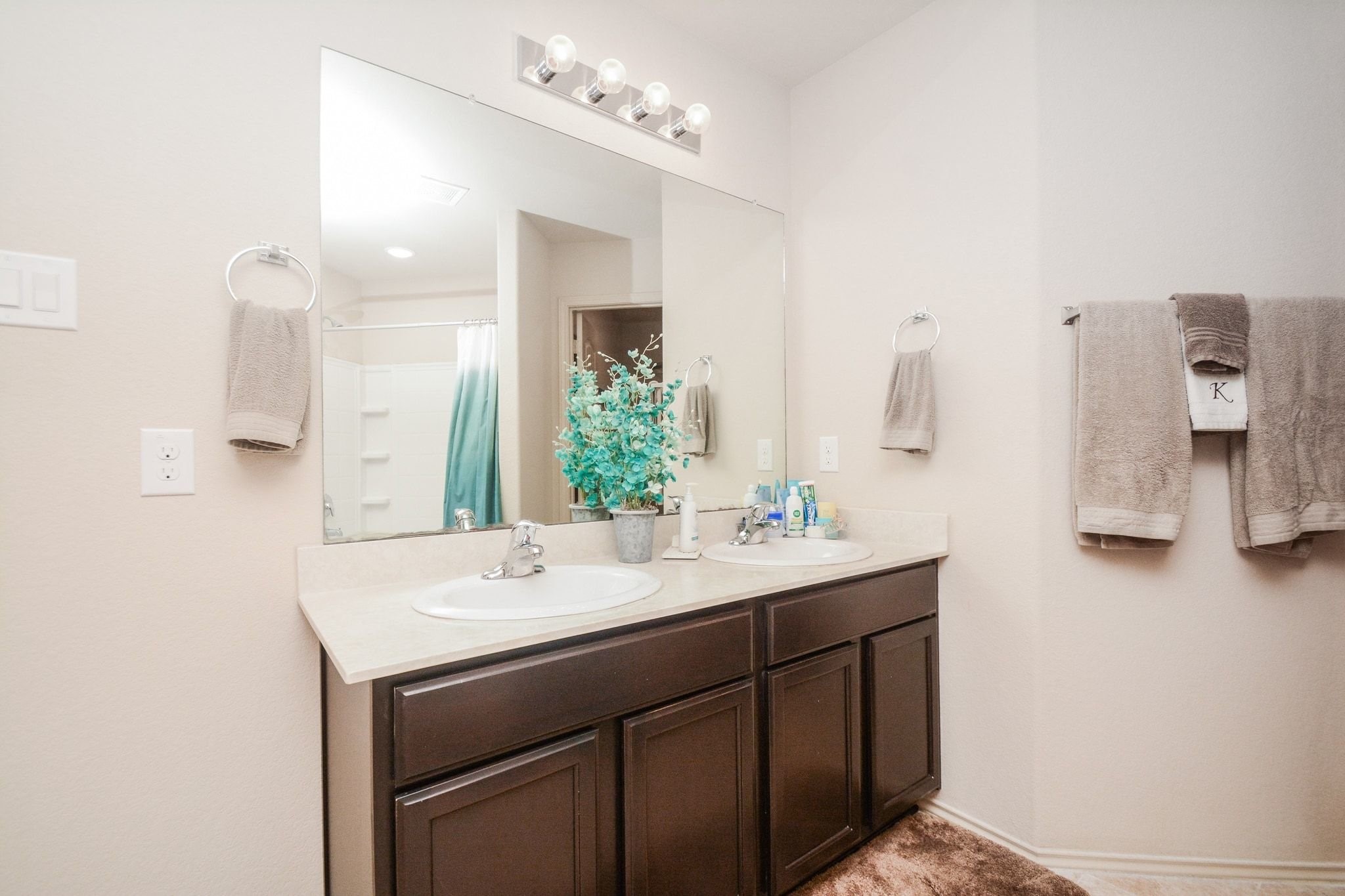 23318 Dukes Run Drive Spring, TX 77373 - Photo 29 of 41 This bathroom features a dual-sink vanity with dark cabinets, a large mirror, and ample lighting. Neutral tones create a warm, inviting atmosphere, and there's a shower and soaking tub.
