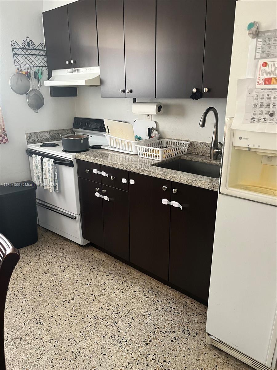 37 Northwest 19th Avenue Miami, FL 33125 - Photo 3 of 9 a kitchen with stainless steel appliances granite countertop a sink stove and cabinets