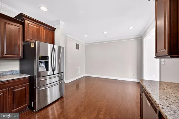a kitchen with stainless steel appliances granite countertop a refrigerator and a stove top oven