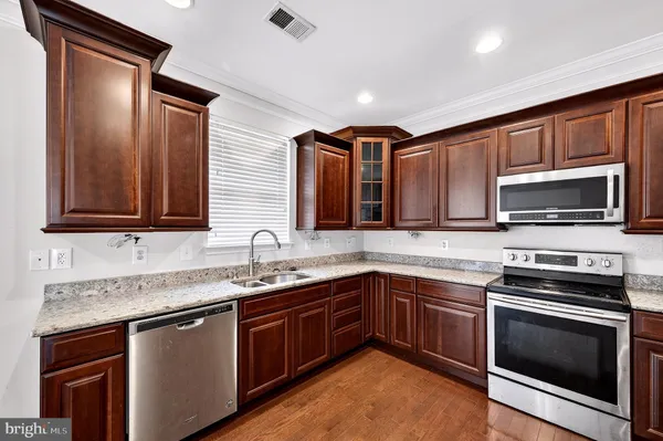 a kitchen with stainless steel appliances granite countertop a sink stove and microwave