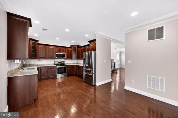 a kitchen with stainless steel appliances kitchen island granite countertop a refrigerator and a stove top oven