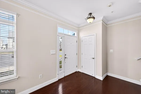 a view of an empty room with wooden floor and windows