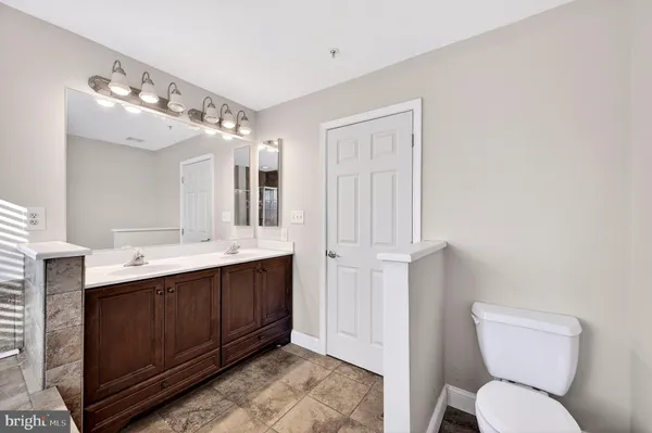an empty room with chandelier fan and windows