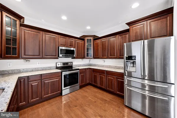 a kitchen with granite countertop stainless steel appliances and wooden cabinets