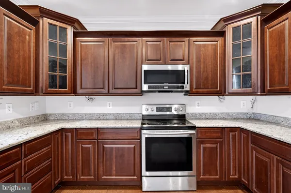 a kitchen with granite countertop a sink stove and microwave