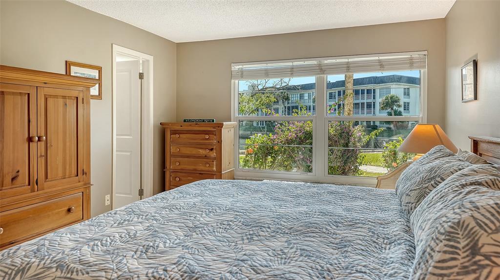4380 Exeter Drive, Unit H103 Longboat Key, FL 34228 - Photo 19 of 51 a bedroom with a bed and a window