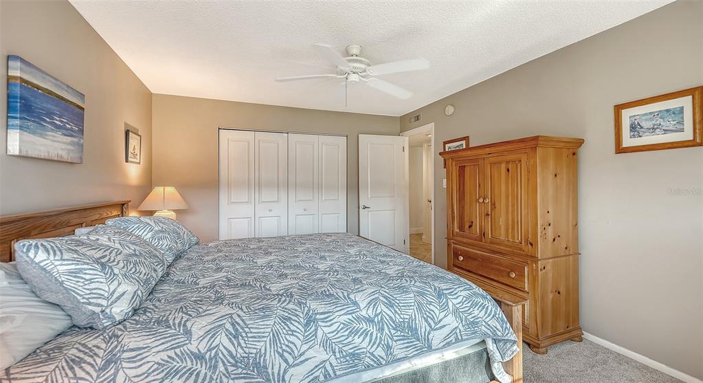 4380 Exeter Drive, Unit H103 Longboat Key, FL 34228 - Photo 20 of 51 a bedroom with a large bed and a chandelier