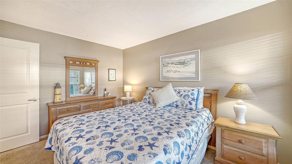 4380 Exeter Drive, Unit H103 Longboat Key, FL 34228 - Photo 24 of 51 a bedroom with a large bed and a chandelier
