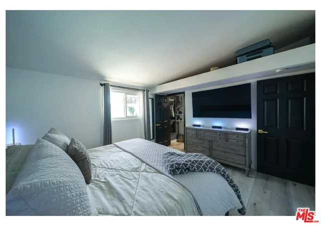 a bedroom with a bed and a flat screen tv