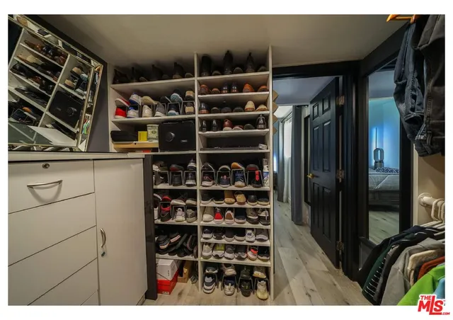 a view of walk in closet with clothes and shoes