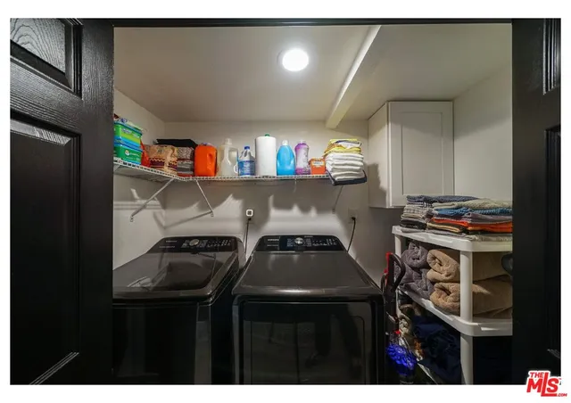 a kitchen with a refrigerator and a stove with wooden floor