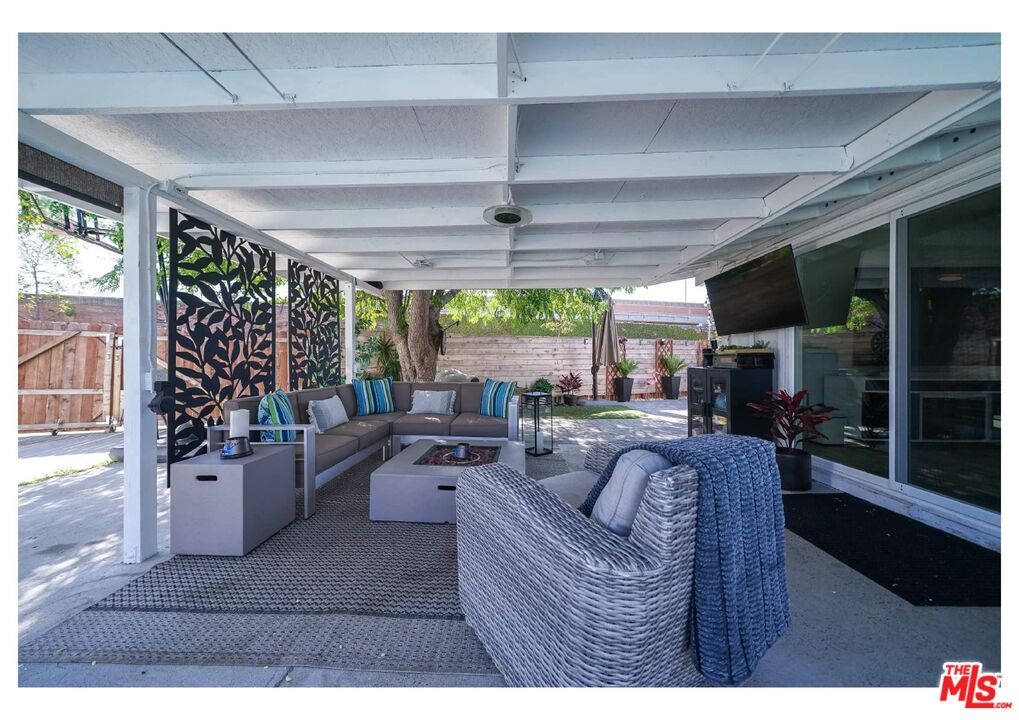 848 West Irving Place Anaheim, CA 92805 - Photo 30 of 33 a living room with furniture a flat screen tv and a floor to ceiling window